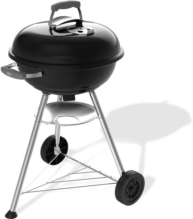 Svart Weber Compact Kettle klotgrill med kromat galler och trebensstativ på hjul, 47 cm i diameter